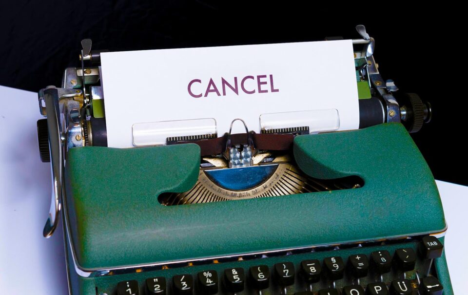 typewriter with a piece off paper reading CANCEL